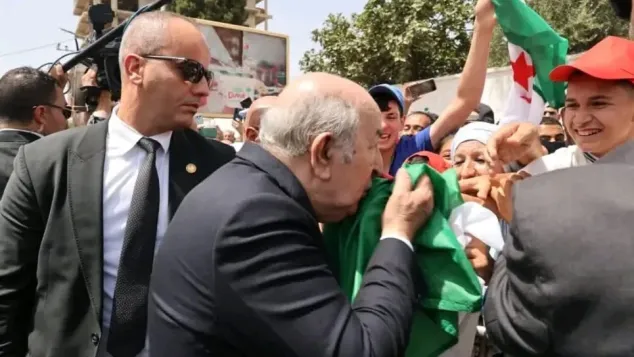 رئيس الجمهورية، عبد المجيد تبون، يقبل الراية الوطنية، الصورة: ح.م.